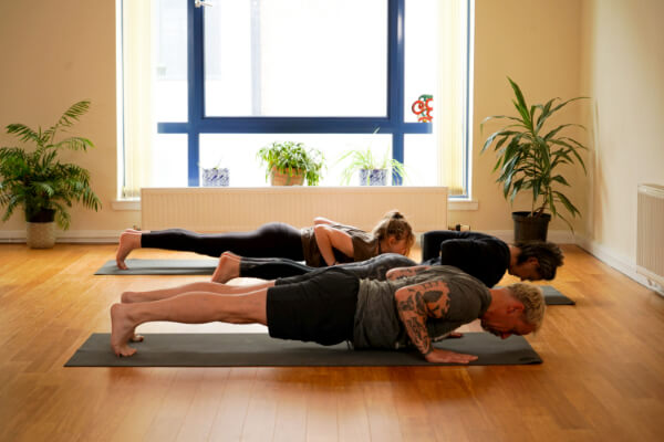 Man and woman in push up position on yoga mat